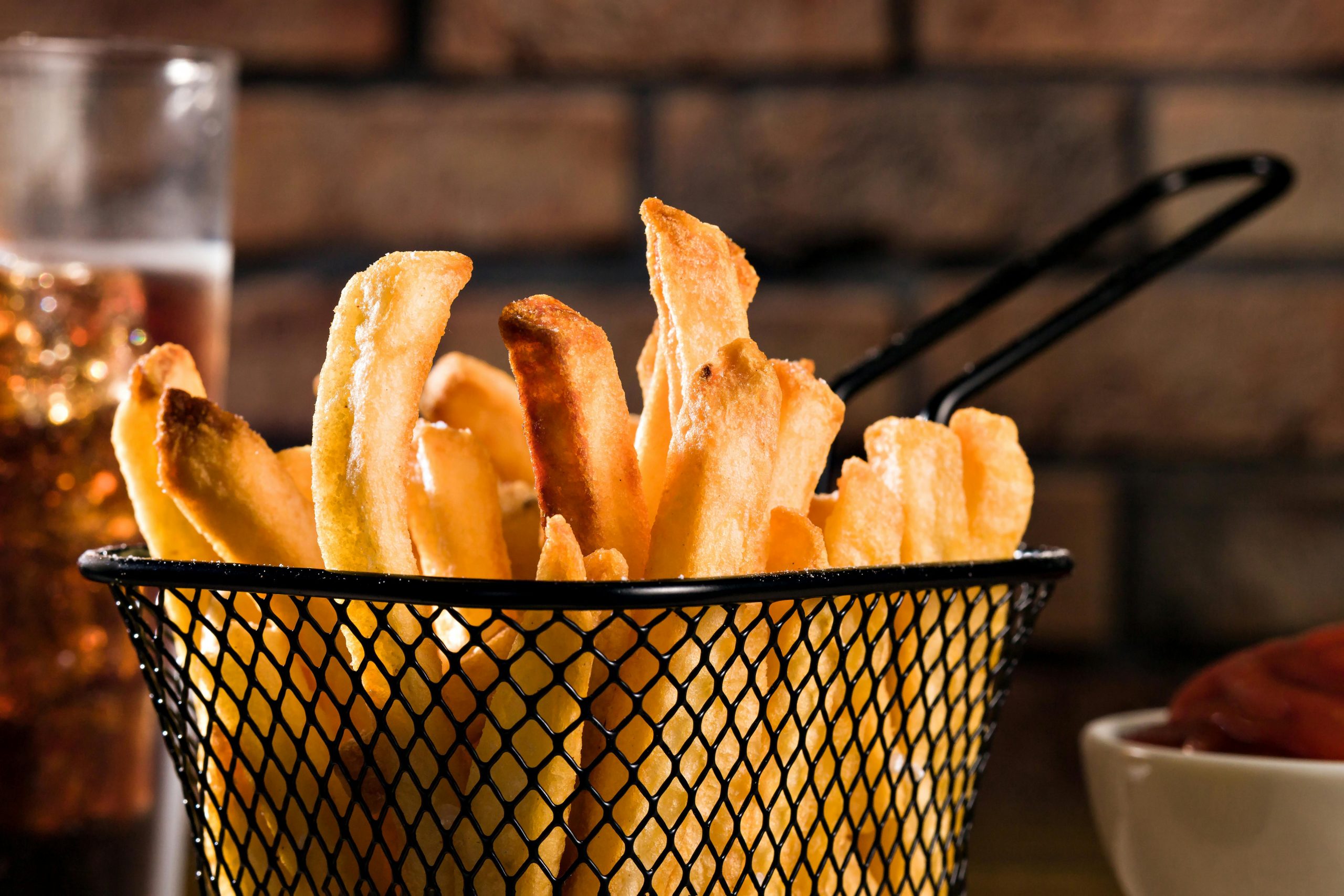 Delicious golden, crispy, and light french fries are served in a basket.